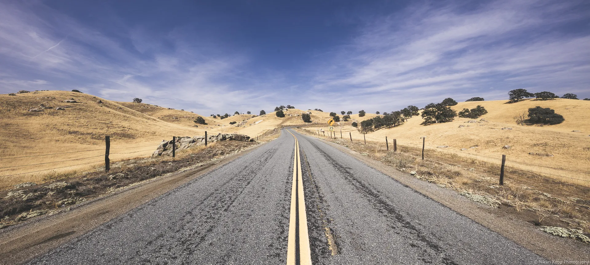 An empty road forming a leading line through a wide California landscape
